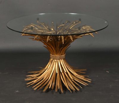 an image of a table with a glass top and gold leaves on it