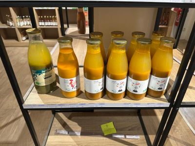 Plusieurs bouteilles de jus d'orange sont posées sur une étagère dans un magasin