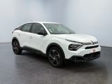 a white car is parked in a room with a black floor