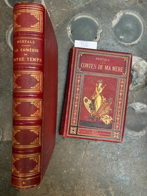 un livre rouge posé à côté d'un autre livre rouge par terre