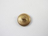a close up of a gold button on a white surface