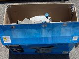 une boîte en carton avec un couvercle bleu posée par terre