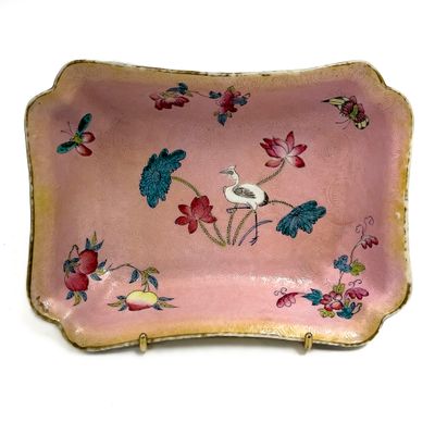 une assiette rose décorée d'un oiseau et de fleurs