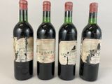 three bottles of red wine are lined up on a white surface