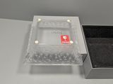 a clear box with a black lid and a black box with a red tag