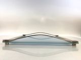 a glass plate with a metal handle on a table