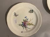 two plates that have flowers on them on a table