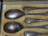 five spoons in a box that are sitting on a table