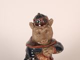 a statue of a monkey wearing a hat and holding a bag