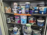 de nombreux pots de peinture sur les étagères de la pièce