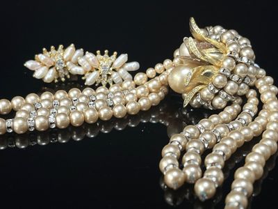 collier et boucles d'oreilles en perles sur un fond noir avec des reflets