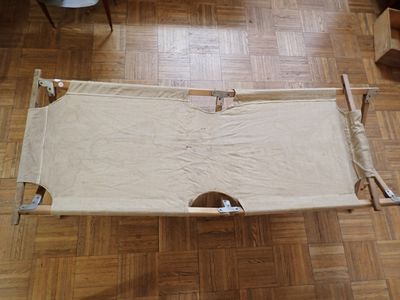 a cot that is on a wooden floor in a room