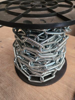 une bobine de chaînes et des chaînes posées sur une table