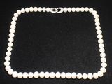 un collier de perles blanches sur fond noir