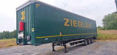 a green semi trailer that is parked on the side of the road