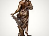 a bronze statue of a woman holding a flower on a marble base
