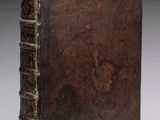 un vieux livre à la couverture brune posé sur une table
