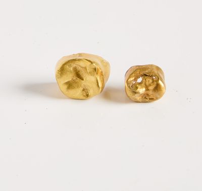 a pair of gold plated earrings on a white surface