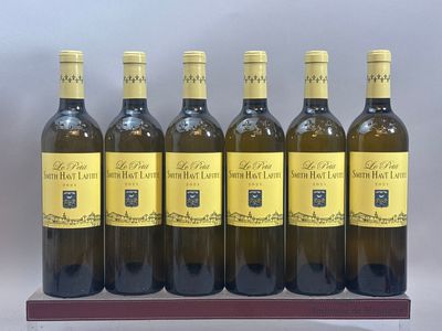 six bouteilles de vin blanc sont alignées sur un support en bois