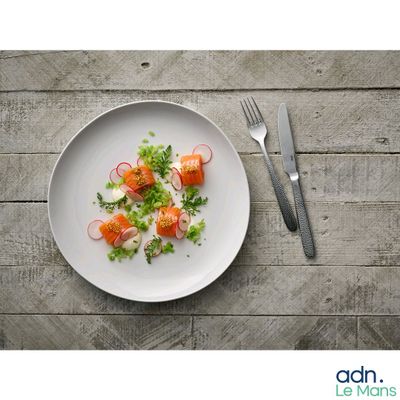 une assiette de nourriture posée sur une table en bois, avec une fourchette et un couteau