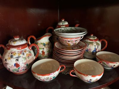 de nombreuses tasses et soucoupes posées sur une étagère dans un vaisselier