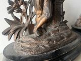 a bronze statue of a man with a bird on his shoulder