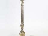 une lampe de table en laiton ancien sur fond blanc, avec un cordon
