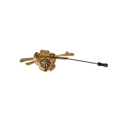 an image of a gold brooch with a bow and arrow on a white background