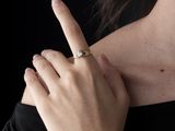 une femme en robe noire, avec une bague au doigt
