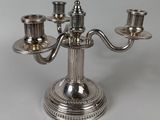 a silver candelab with three candles on it