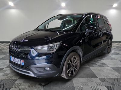 a black car is parked on a checkered floor in a garage