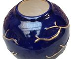a blue vase with a gold leaf design on it