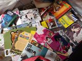 a suitcase full of books and magazines sitting on the floor