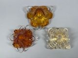 four pieces of glass sitting on top of a table next to each other