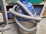 un aspirateur bleu et argent posé dans une pièce