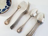 four forks and a bowl of cream on the table