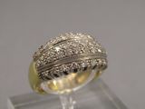 une photo d'une bague en diamant posée sur un socle transparent