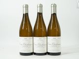 trois bouteilles de vin posées sur une table blanche