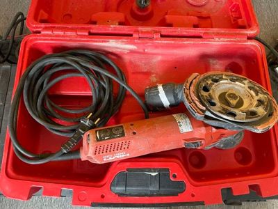 une boîte à outils rouge contenant une perceuse et d'autres outils