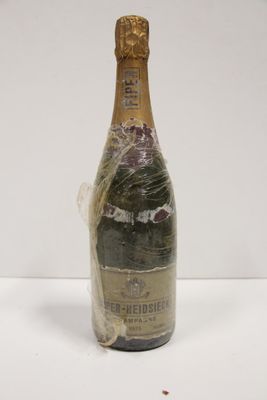 an old bottle of champagne wrapped in plastic on a white surface