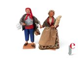 two figurines of a man and a woman standing next to each other
