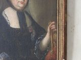 portrait of a woman holding a fan in a painting on a wall