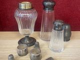 des bouteilles et des salières posées sur une table avec un fond rouge