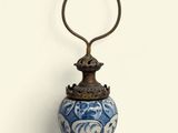 a blue and white vase with a bell on top of it