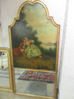 une photo d'un tableau accroché au mur à côté d'un miroir