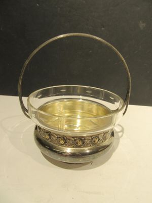 un saladier en verre muni d'une anse, posé sur une table