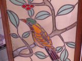 une image d'un oiseau en vitrail assis sur une branche d'arbre