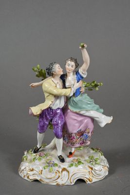 two figurines of a man and a woman on a rock