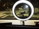 a round mirror on a stand in front of a window