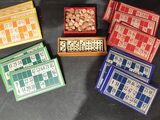 plusieurs boîtes en bois contenant des dés et des dominos, posées sur une table